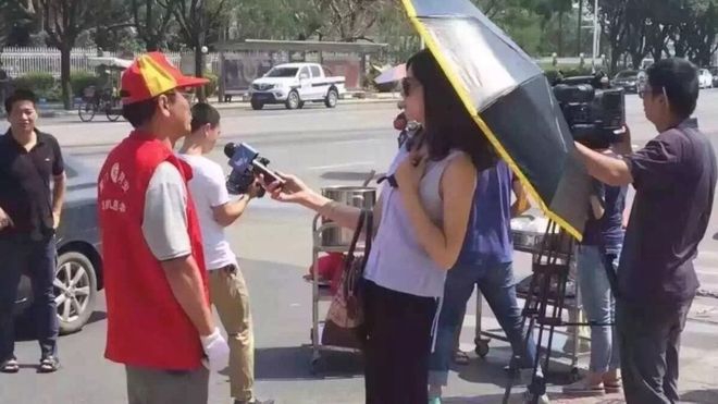 В Китаї журналістку відсторонили від роботи через окуляри і парасольку